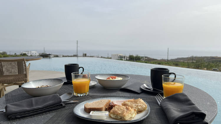 A plate of breakfast food by the pool at Magma Resort, Santorini