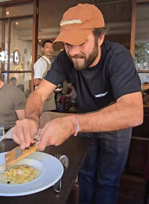O chef Elia ralando trufa na mesa
