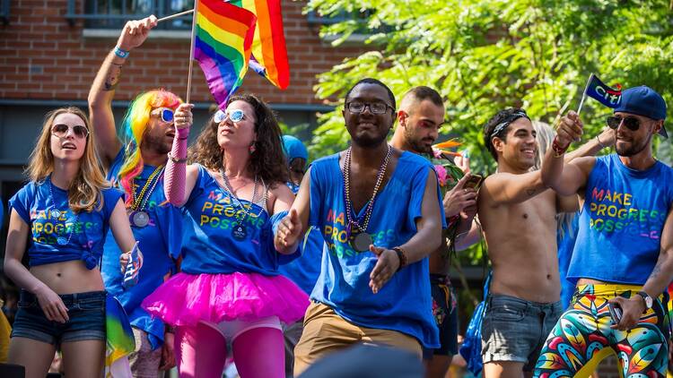Participants wave rainbow flags on a float in the annual Pride Parade as it passes through Greenwich Village.