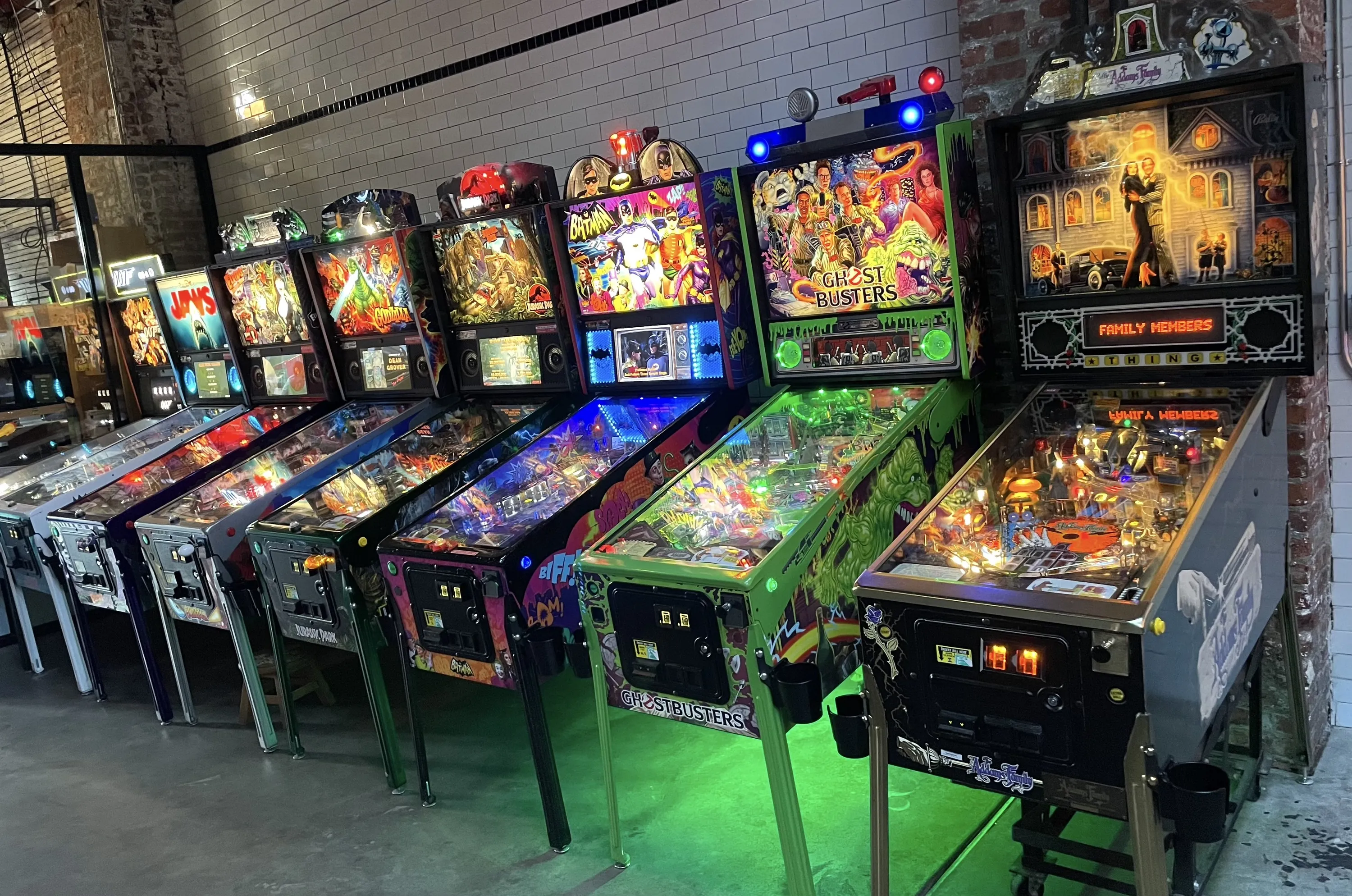 A long line of pinball machines with bright colors.