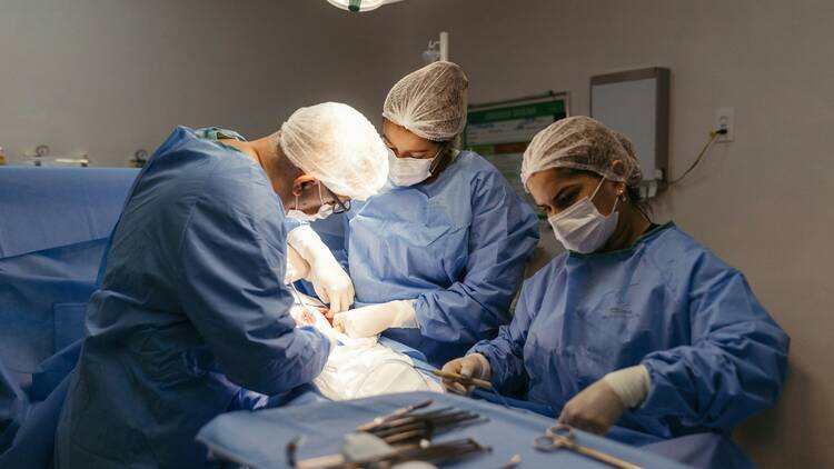 Group of doctors perfomring surgery