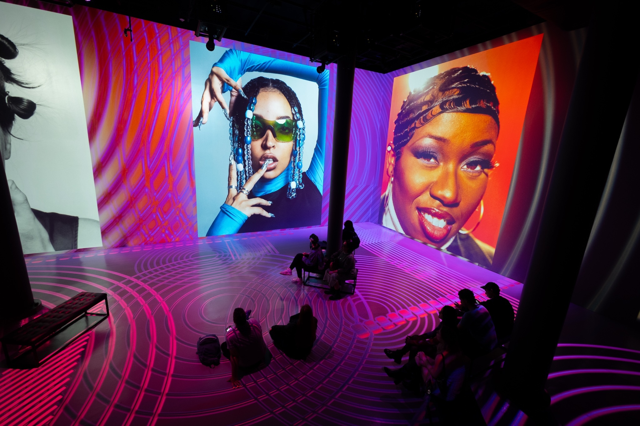 Large portraits of female musicians are projected onto a wall.