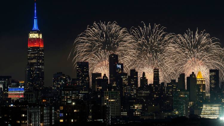 Fireworks light up the sky with the Empire State Building in the foreground.