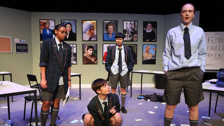 Four classmates in a classroom on stage