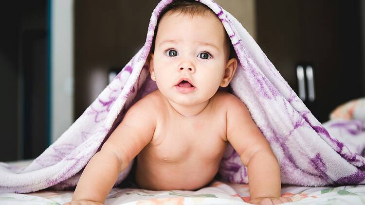 Baby under purple blanket