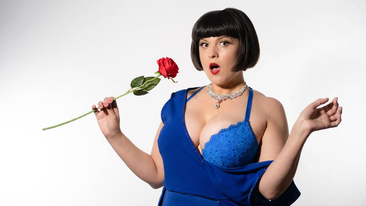 A woman in a blue dress and bra holds a red rose. A woman in a blue dress and bra holds a red rose.