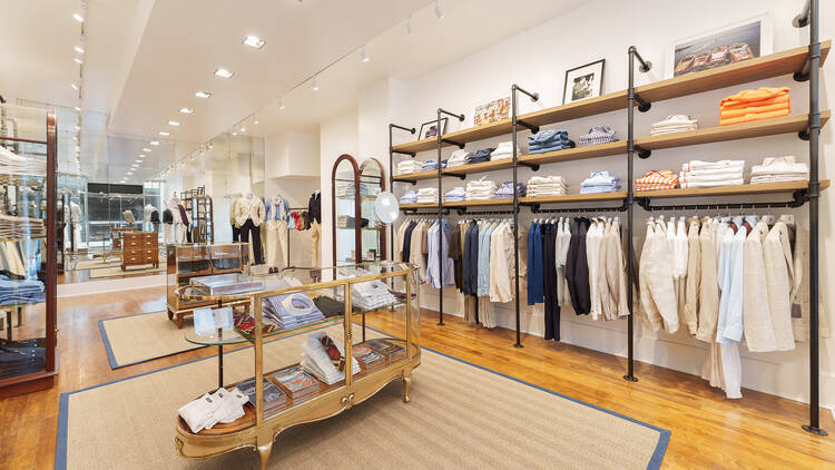 The inside of a menswear shop with suits on display.