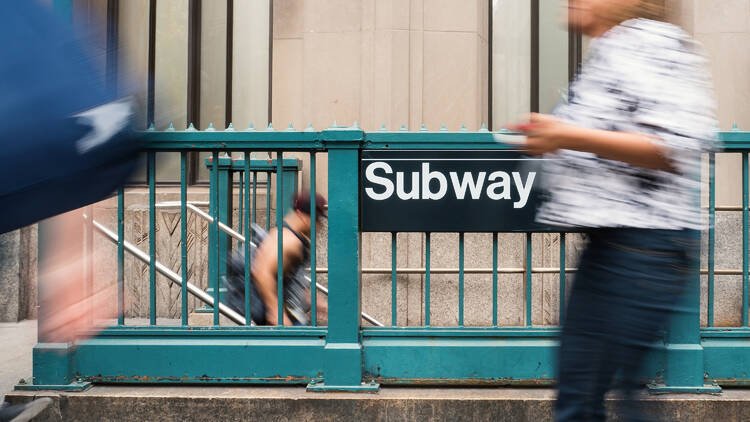 People walking in front of NYC subway entrance