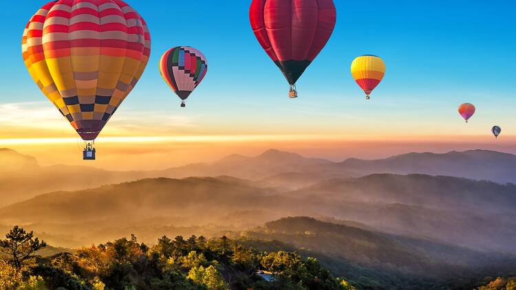 Colorful hot air balloons flying over mountain at Dot Inthanon in Chiang Mai, Thailand.