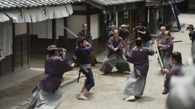 A screengrab from a movie showing people with swords.