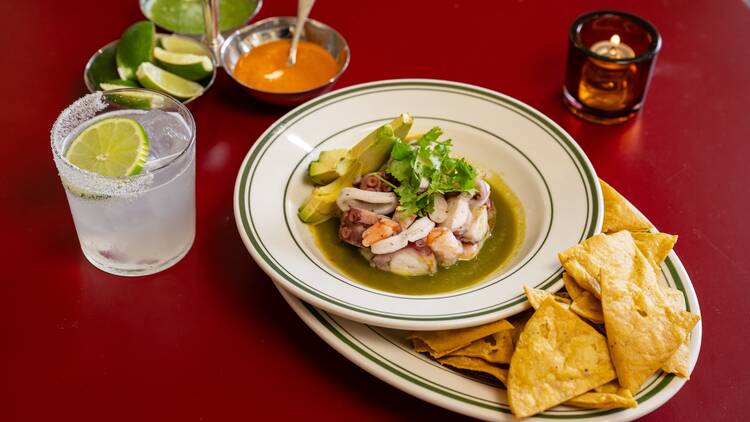 The  Pressed Seafood Aguachile in a bowl with a margarita