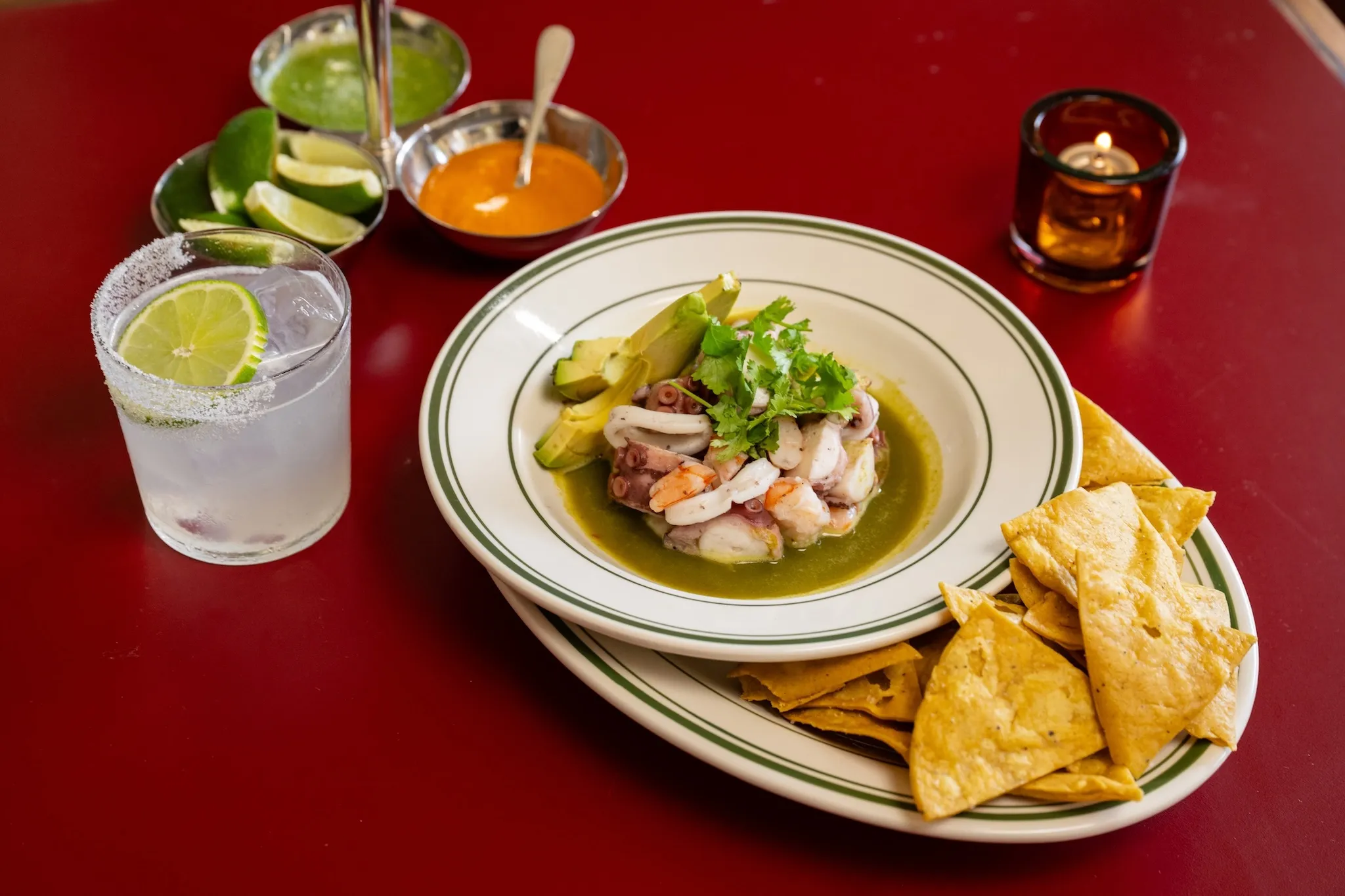 The Pressed Seafood Aguachile in a bowl with a margarita
