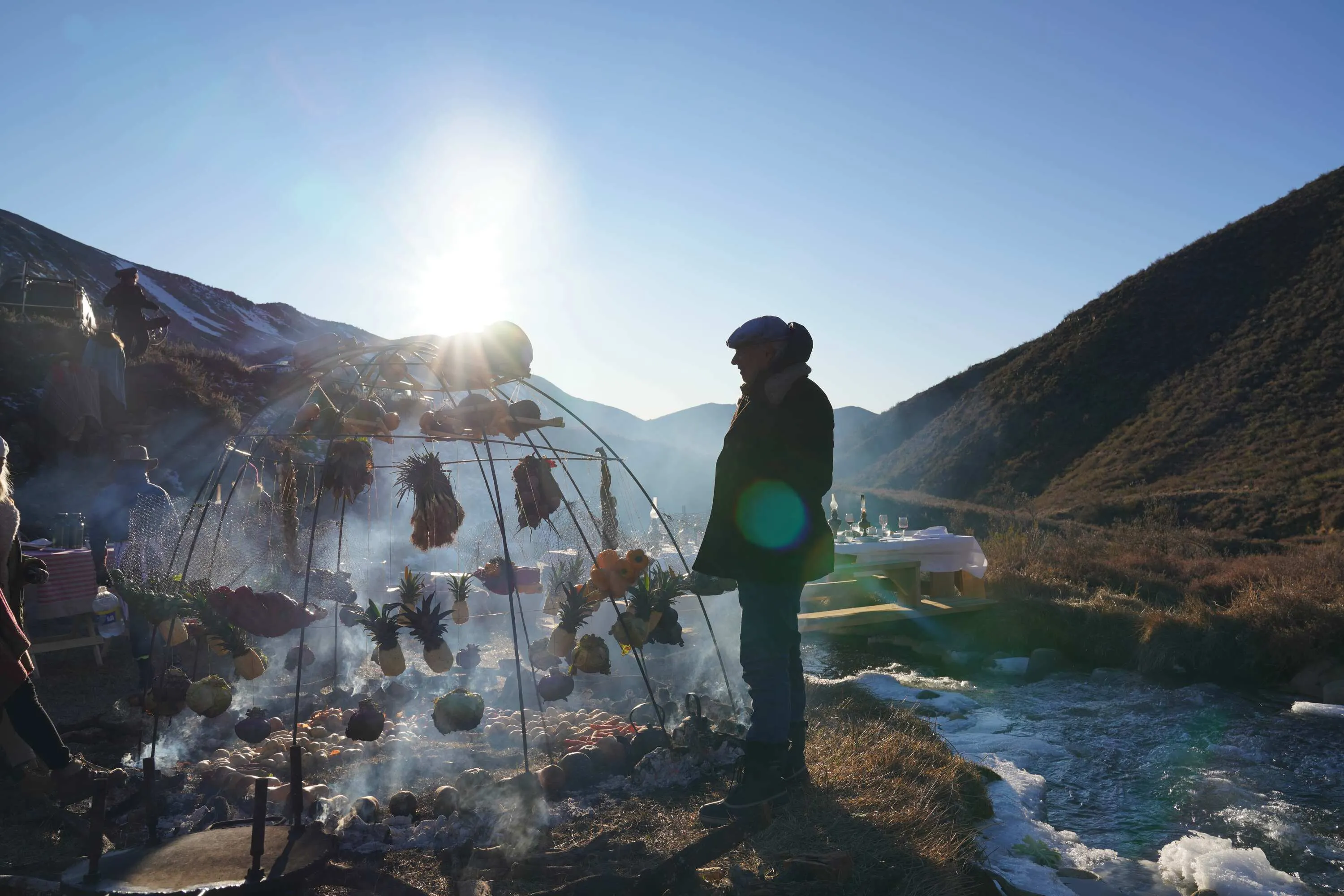 Man standing next to open-fire grill