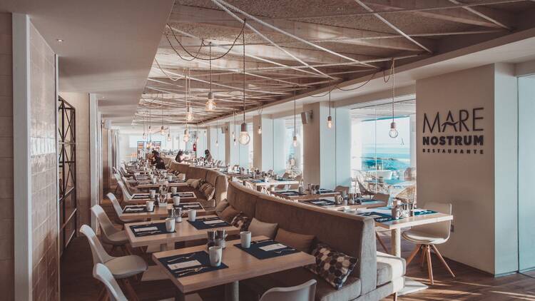Mare Nostrum restaurant with beige chairs and wooden tables