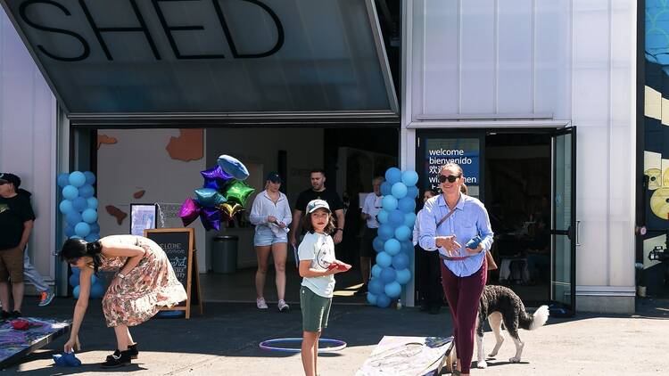 people standing in front of balloons and cornhole people standing in front of balloons and cornhole