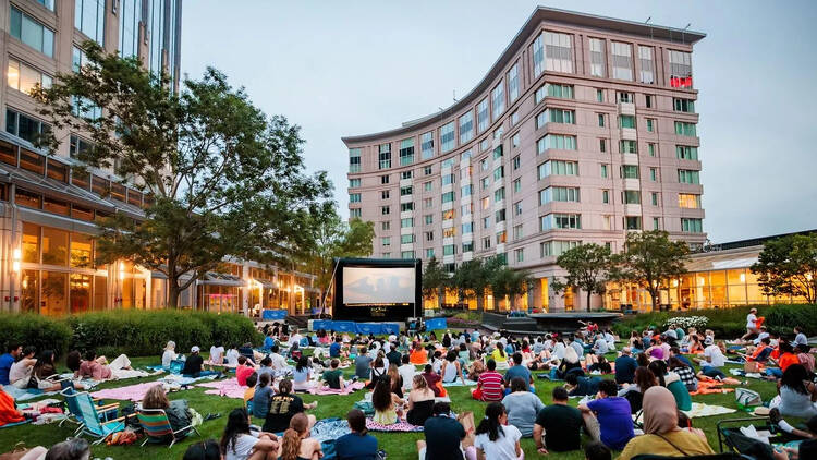 crowd sittin on a lawn watching outdoor movie screen crowd sittin on a lawn watching outdoor movie screen