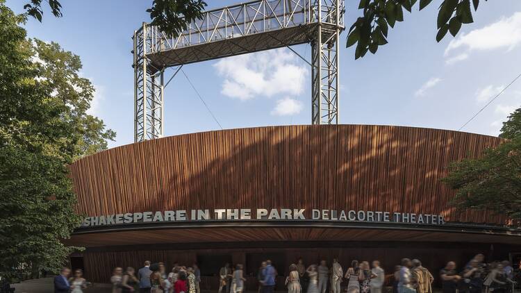 Exterior of the newly renovated Delacorte Theater with people standing outside.