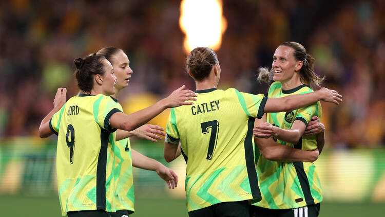 Four female football players on field