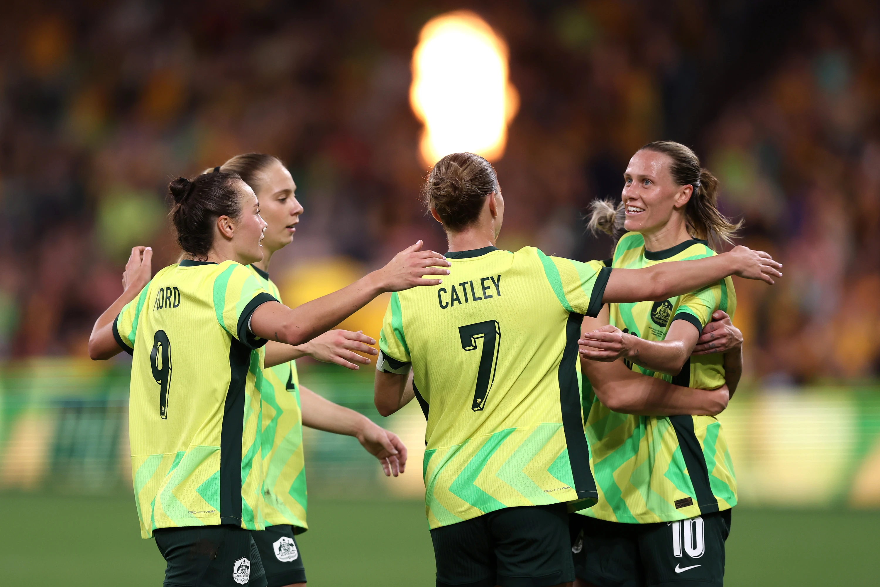 Four female football players on field