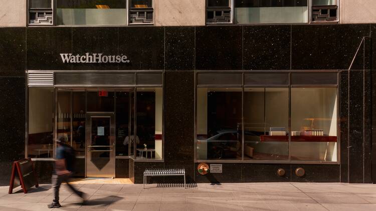 A person walking by the exterior of the WatchHouse
