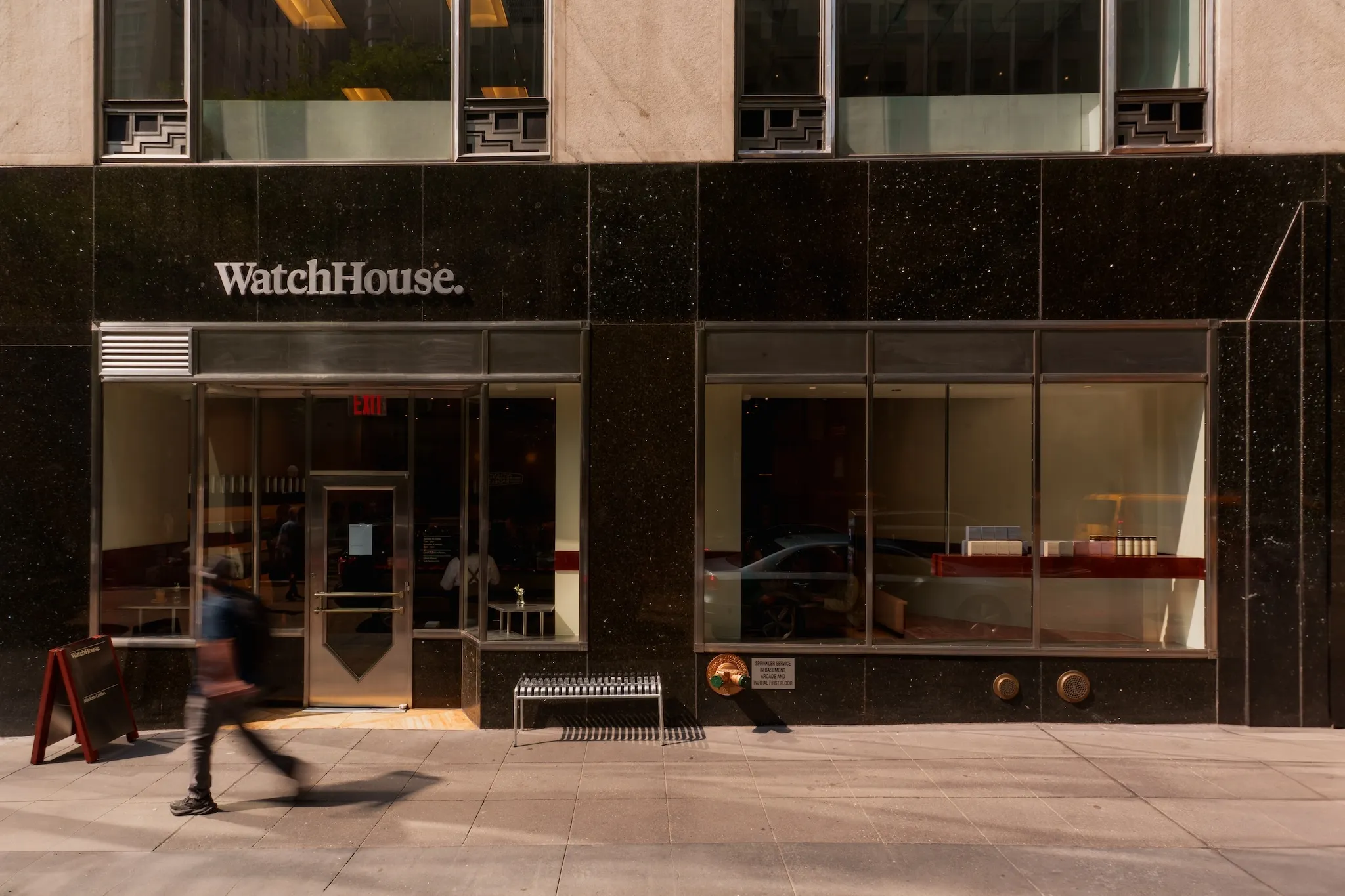 A person walking by the exterior of the WatchHouse