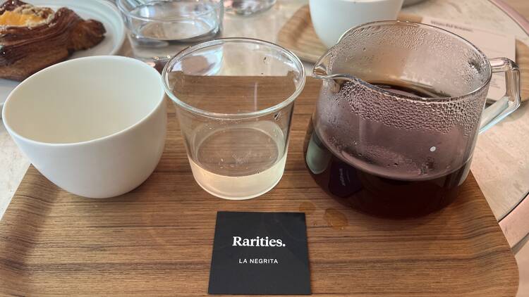 A wooden tray with an empty cup, a cup with tea and a cup of coffee