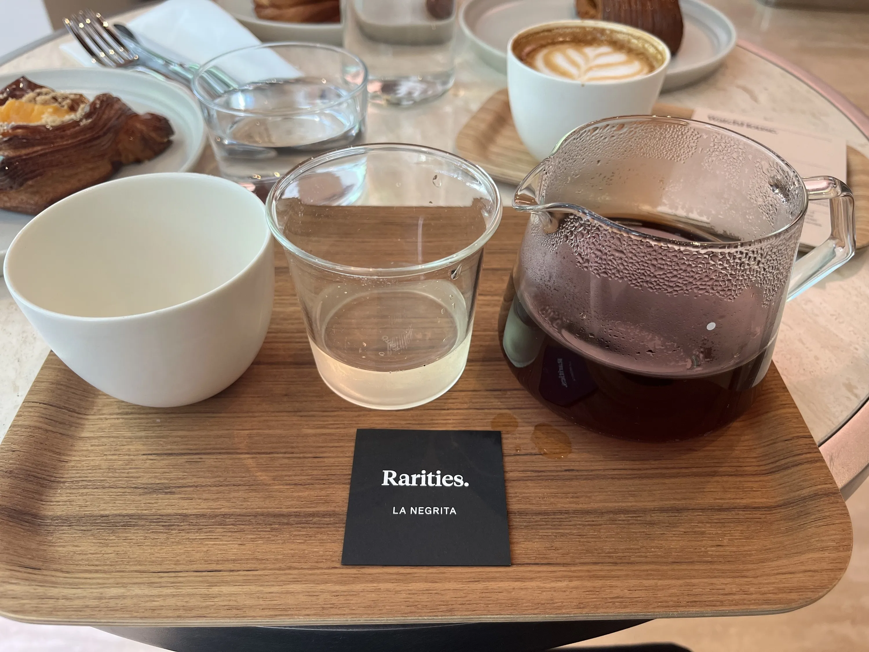 A wooden tray with an empty cup, a cup with tea and a cup of coffee