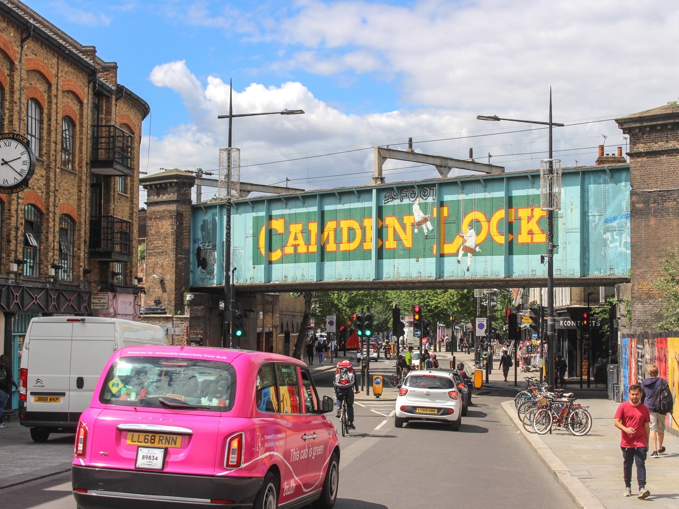 Cars driving underneath the bridge in Camden painted with the words Camden Lock