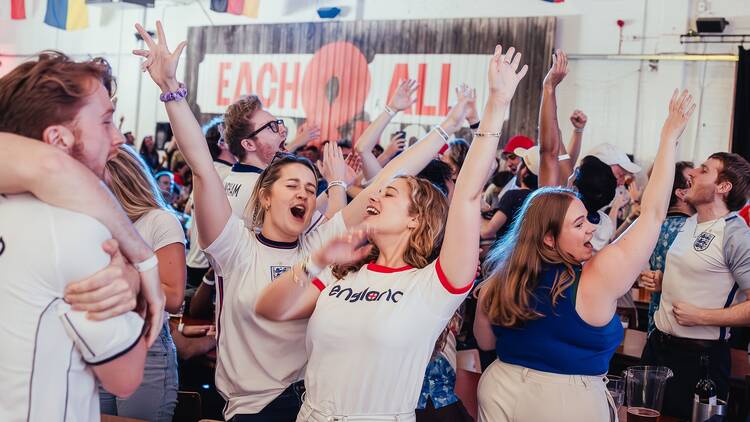 A crowd of England fans celebrating at Big Penny Social