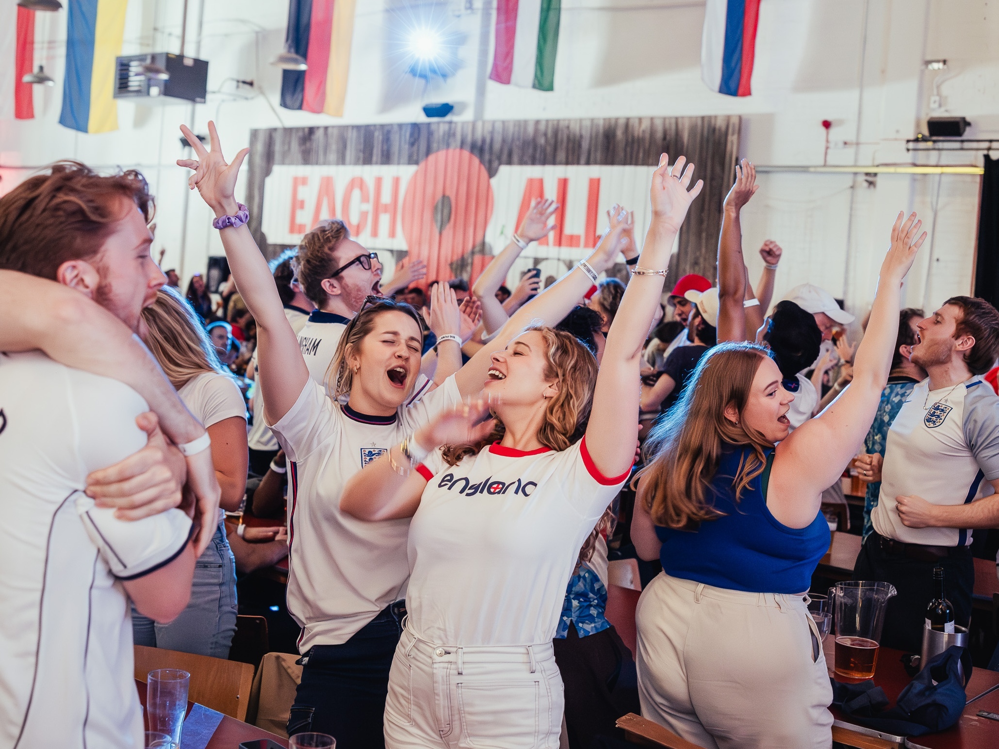 A crowd of England fans celebrating at Big Penny Social