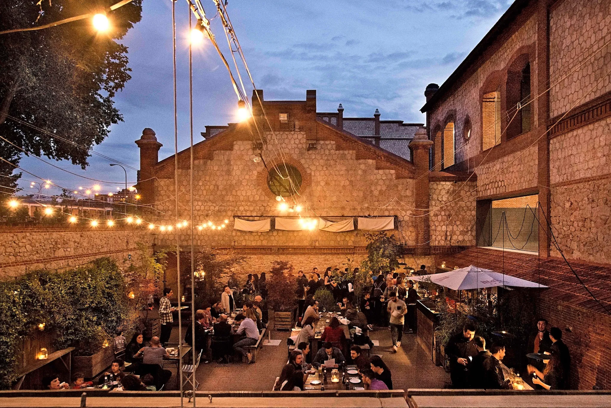 People sitting outside in a Madrid courtyard-style bar