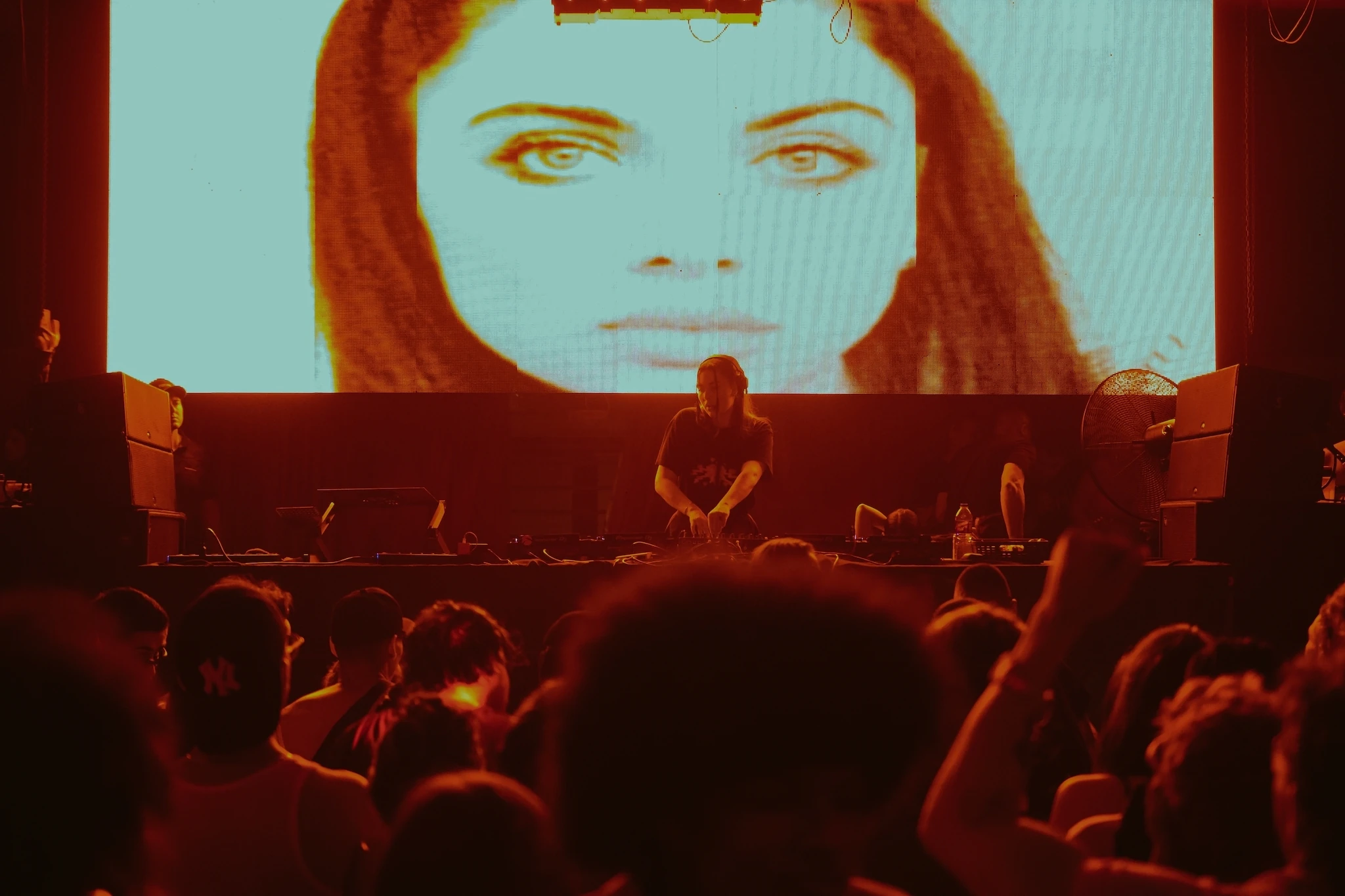 Nightclub with woman's face projected behind DJ in Medellin, Colombia