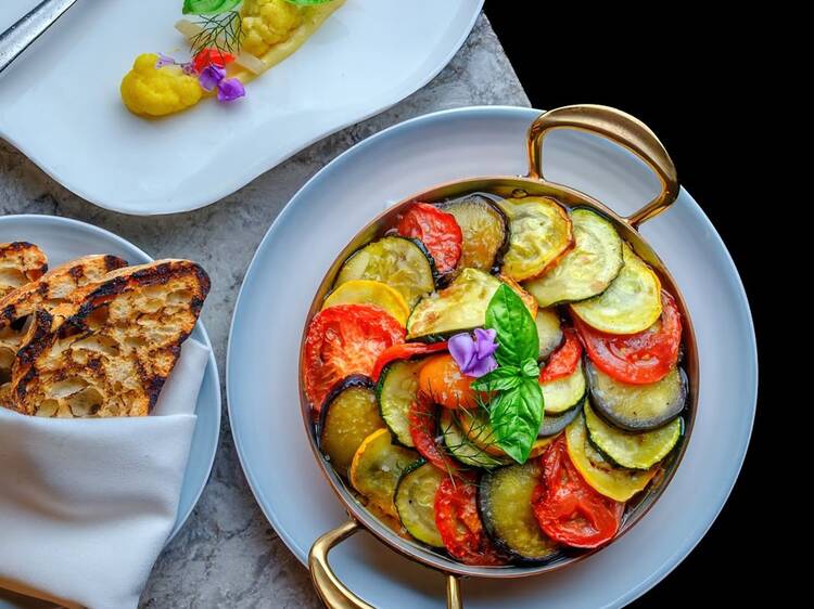 Ratatouille on a white dish with bread