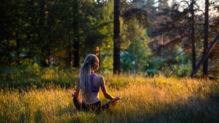 Woman meditating in the woods