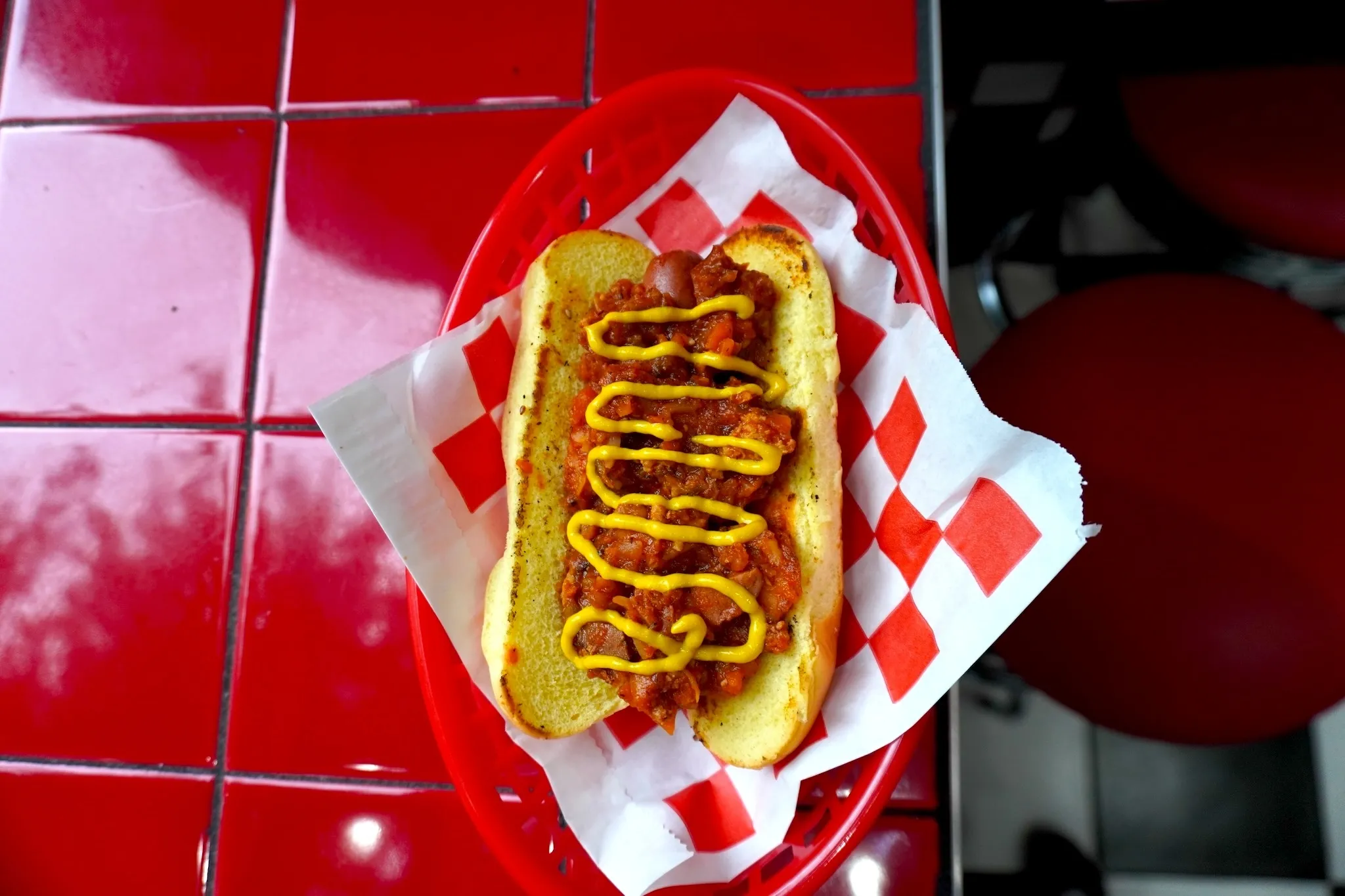 A hot dog with cajun chili and mustard