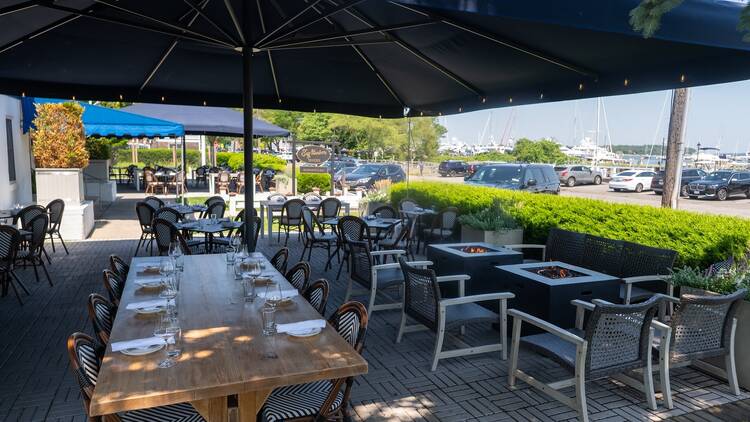 A patio with wooden tables under an umbrella