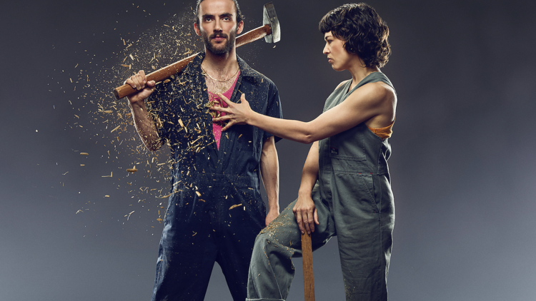 Woman throwing woodchips at a man with an axe