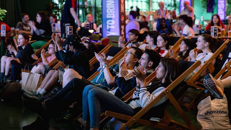A crowd of fans sitting on deckchairs watching a game