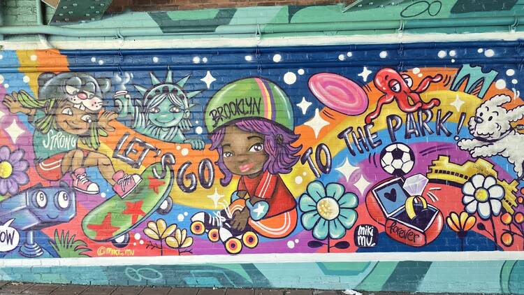 A colorful mural shows kids in comic-book style playing outside.