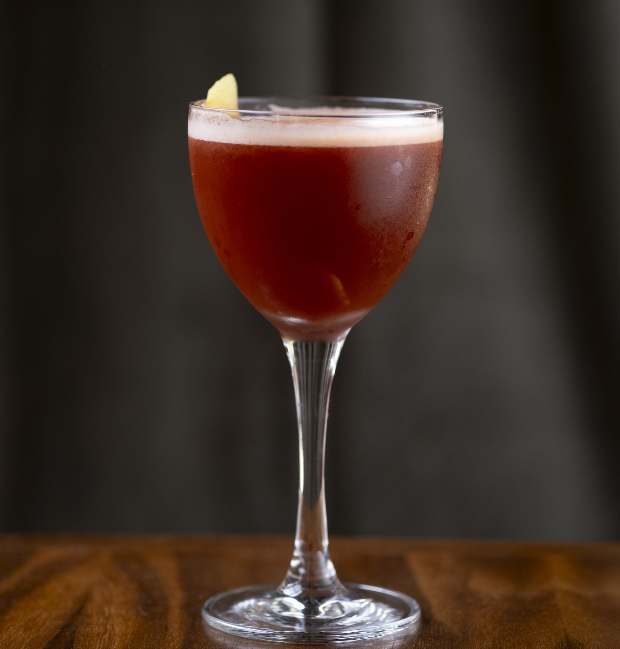 A reddish cocktail in a coupe glass