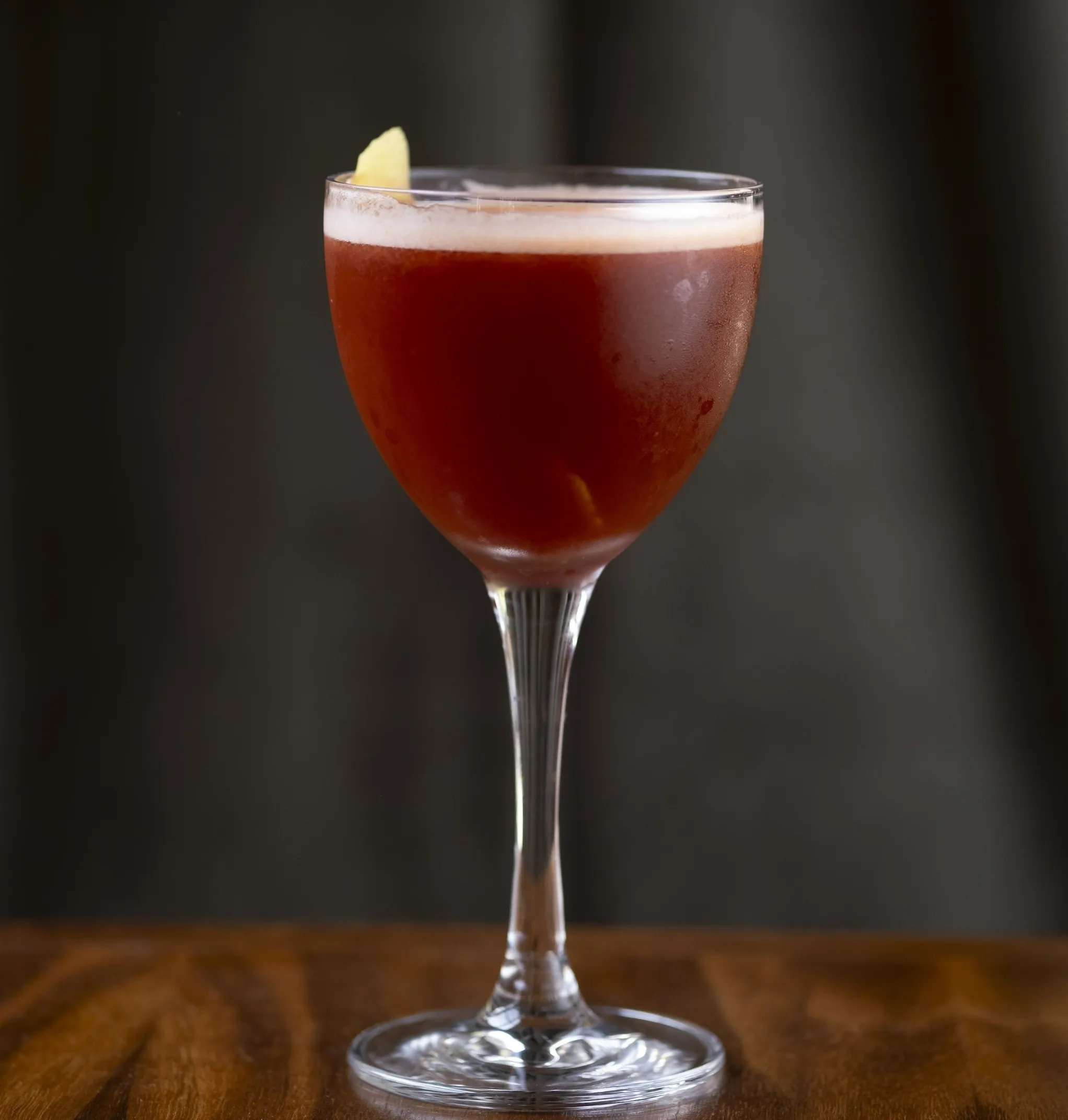 A reddish cocktail in a coupe glass