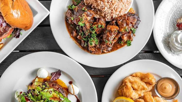 A dinner table of burgers, salad and rice and peas