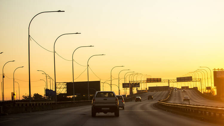 Cars driving down a quiet highway towards the dawn on a weekend in Johannesburg South Africa,