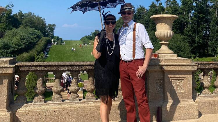 man standing with a woman holding a vintage umbrella man standing with a woman holding a vintage umbrella