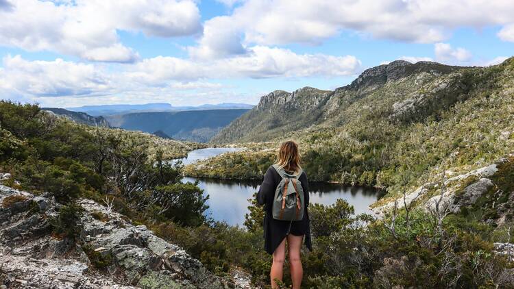 Women standing on top of mountain overlooking lake