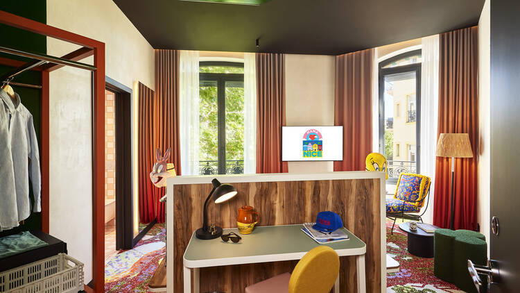 Bedroom at Mama Shelter Nice, showing a desk with a yellow and pink chair
