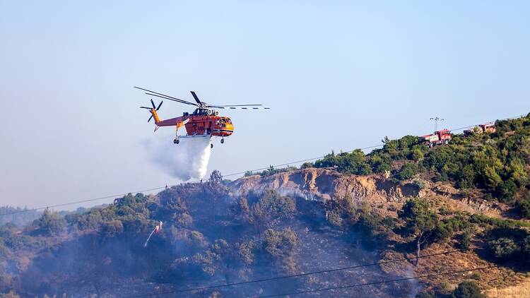 A helicopter tackles a blaze in Izmir, Turkiye