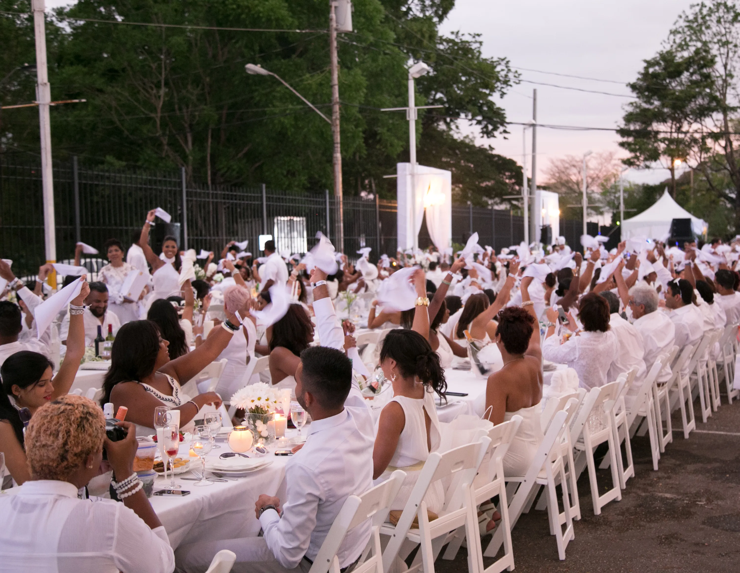 People sitting at long white tables and whipping their napkins around