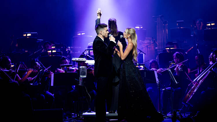 West End stars singing with an orchestra behind them