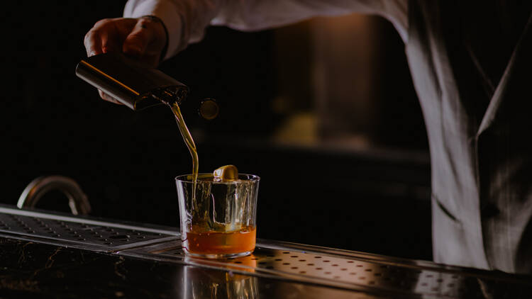 Bartender pouring a Whiskey cocktail